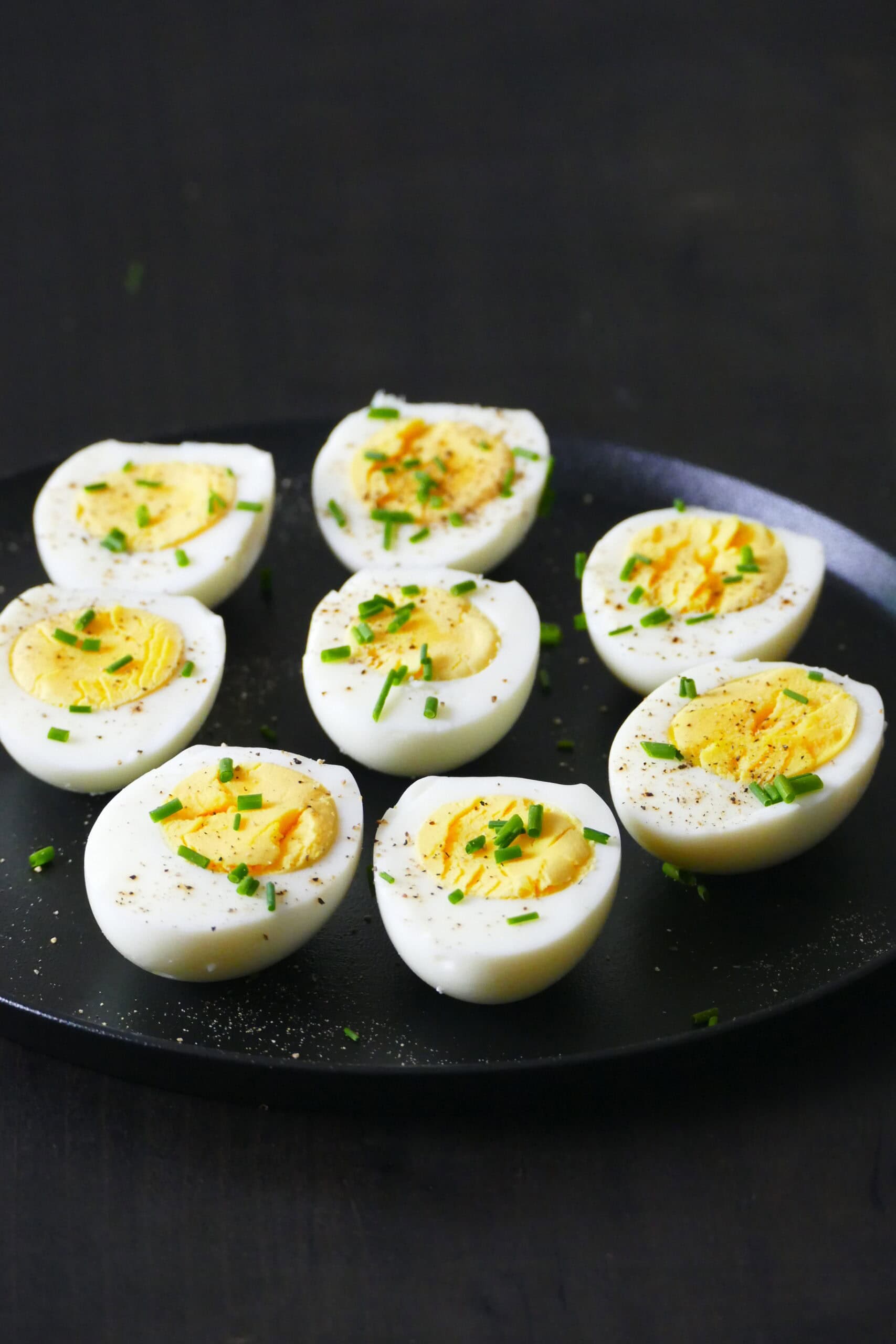 Eight halved Instant Pot 1-minute hard boiled eggs on plate.
