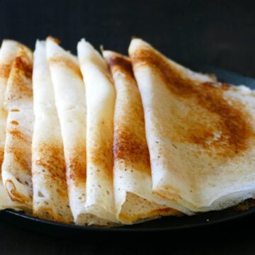 Dosa stacked overlapping on a plate.
