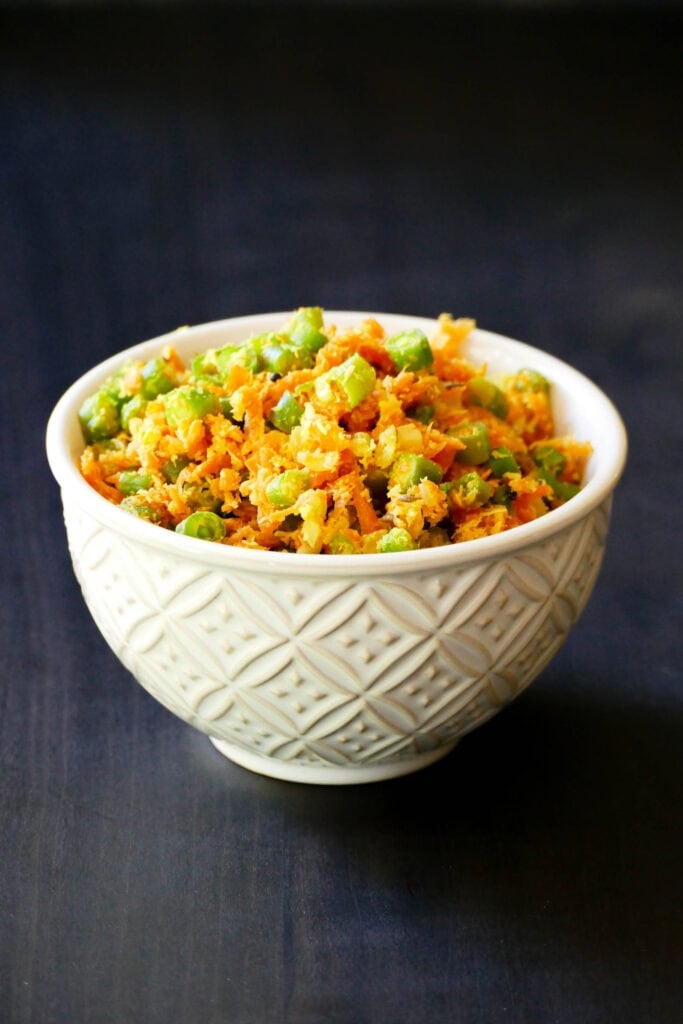 Carrots and green beans thoran in a white bowl.