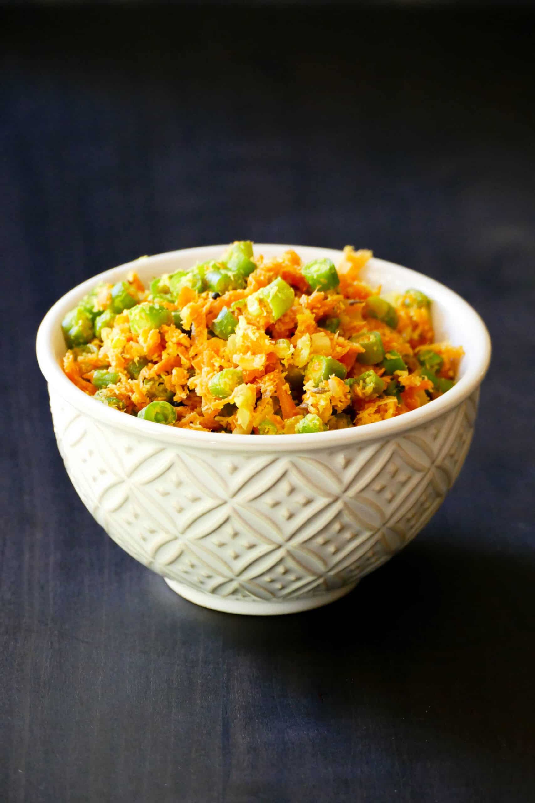 Carrots and green beans thoran in a white bowl.