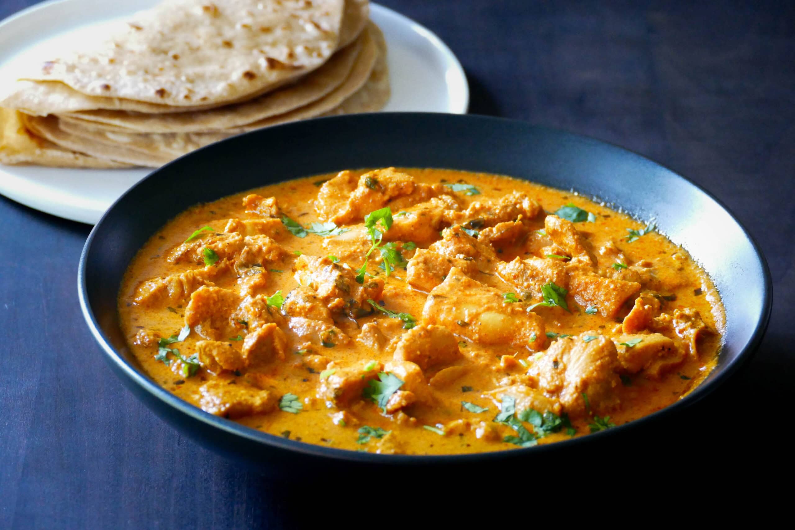 Instant Pot Chicken Tikka Masala in black bowl with rotis.
